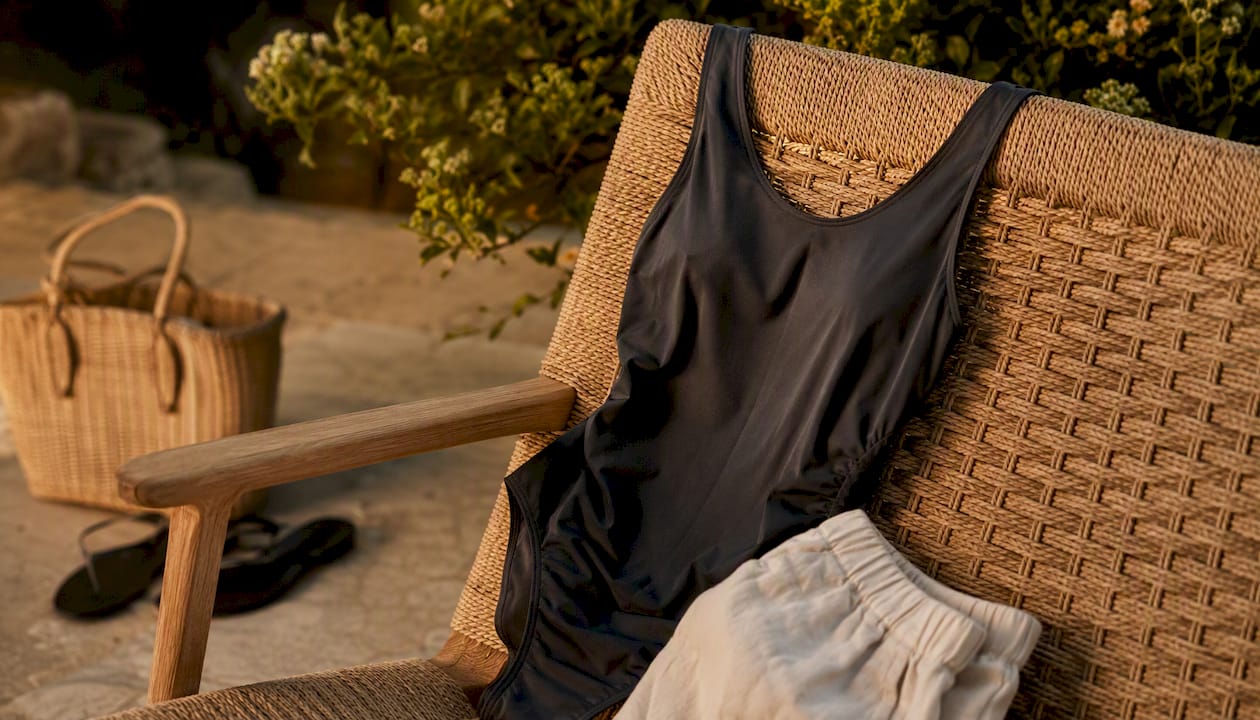 Close-up of one-piece swimsuit with linen trousers detail
