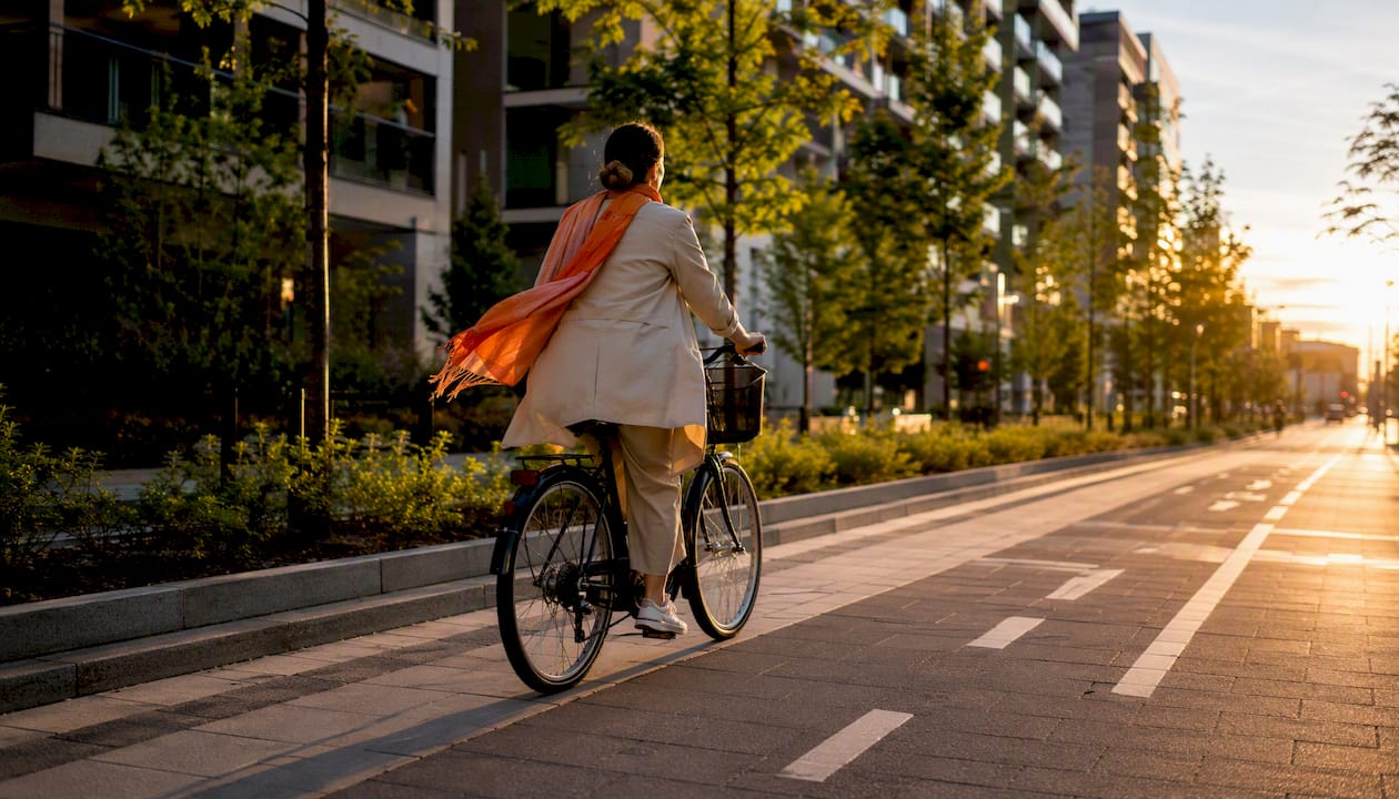 Mujer pedaleando por la ciudad, apostando por una movilidad sostenible.