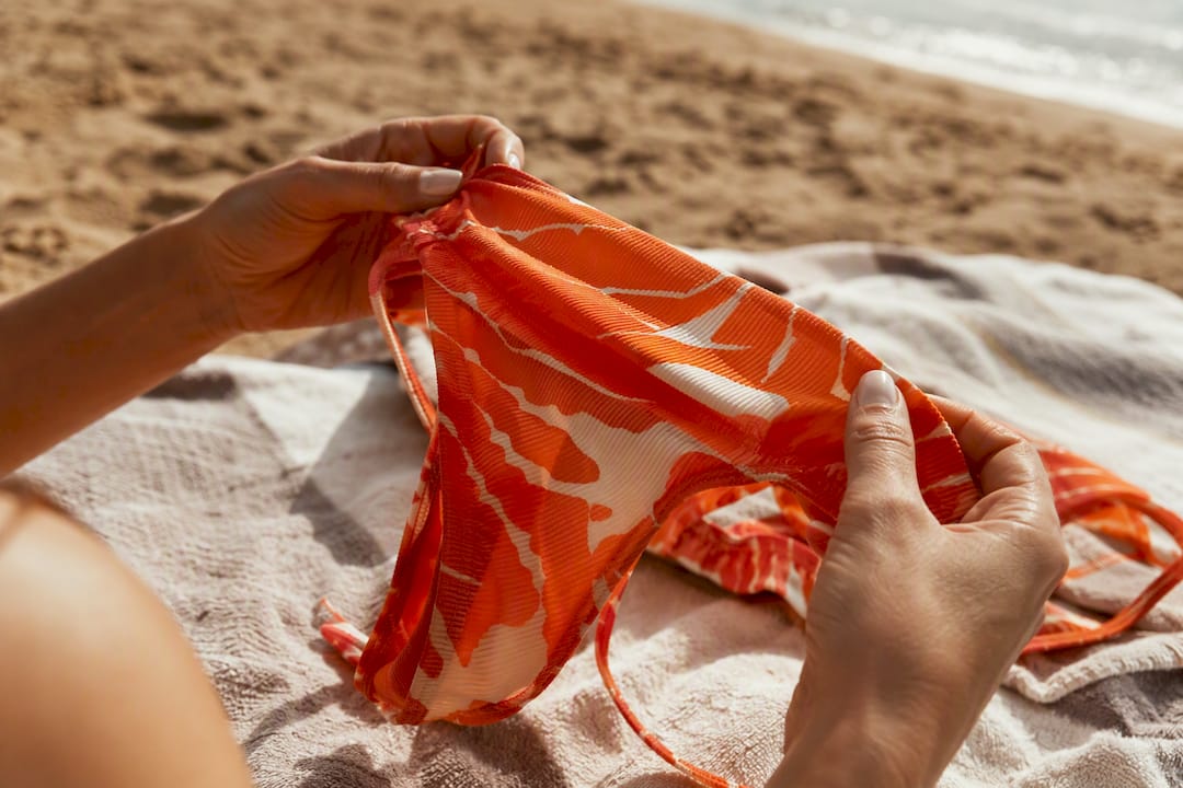 Hands adjusting stretch swimwear fabric