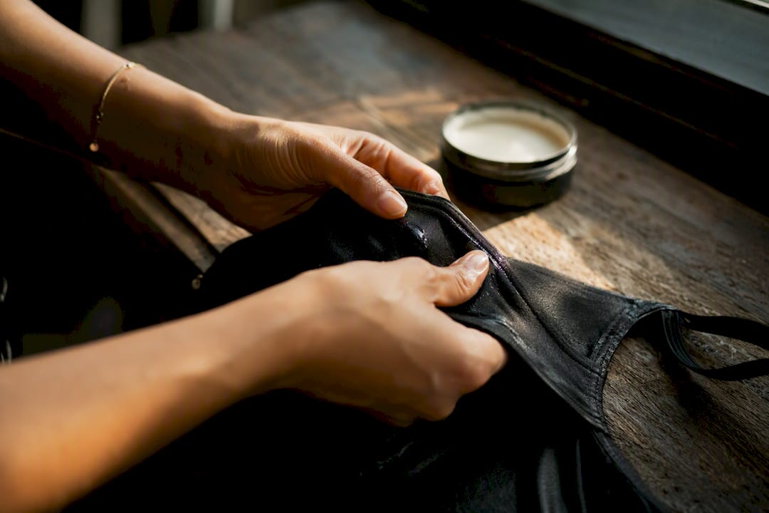 Hands gently brushing swimsuit fabric to preserve elastane