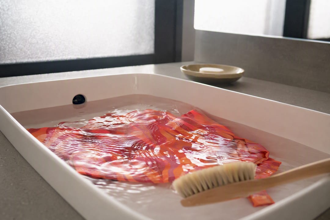 Swimsuit fabric soaking in gentle vinegar solution