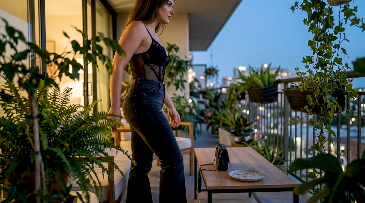 Primer plano de body de noche con encaje y jeans acampanados