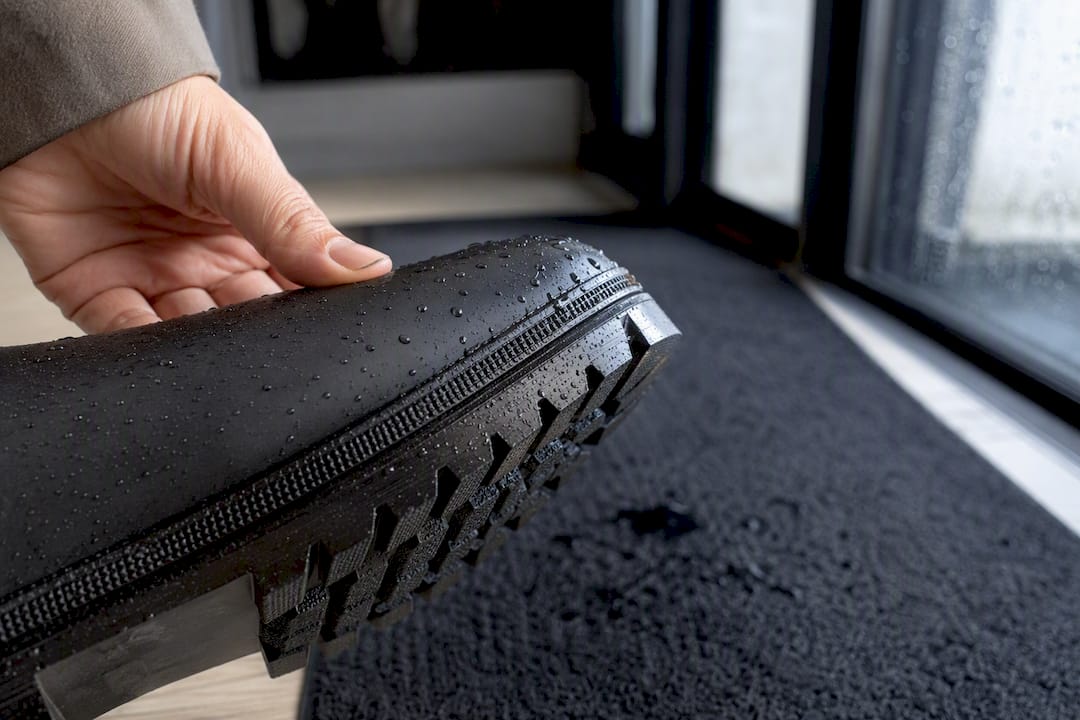 Gros plan sur la semelle d’une botte sous la pluie