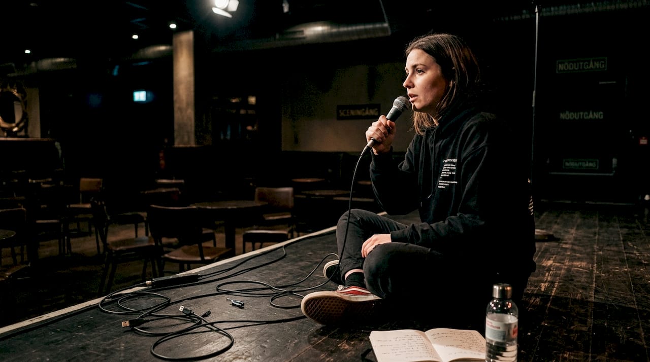 En komiker repeterar sina skämt inför en tom salong.