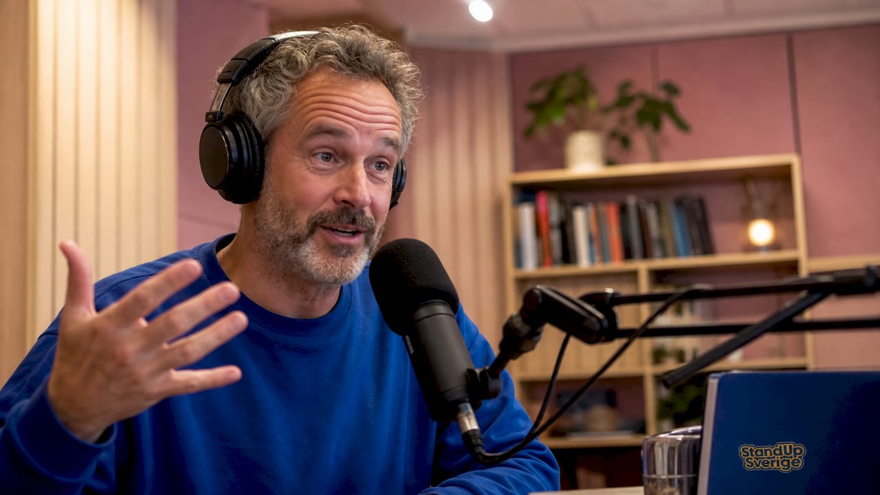 En komiker spelar in sin standup-podd i studion.