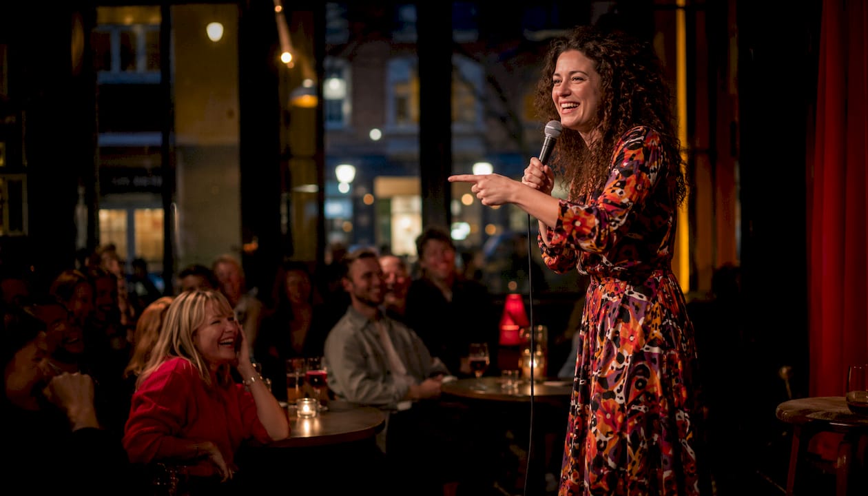 En ståuppkomiker som uppträder inför publik på en comedyklubb.