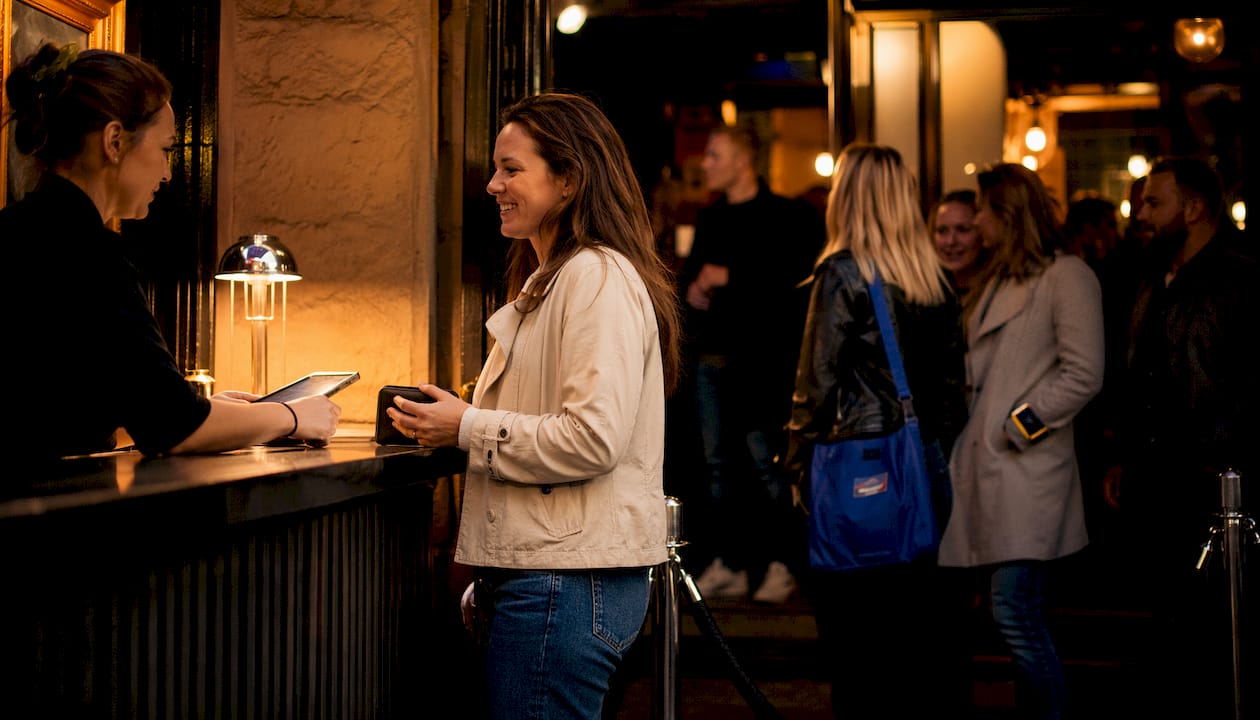 En kvinna köper biljett till en utomhusstandup.