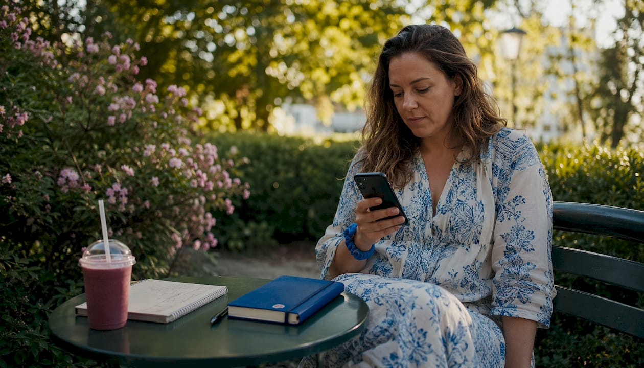 En kvinna använder mobilen för att köpa biljett