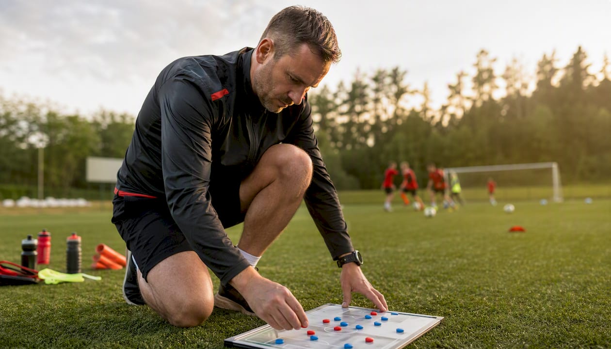 Tränaren skissar laguppställningen på whiteboarden inför matchen.