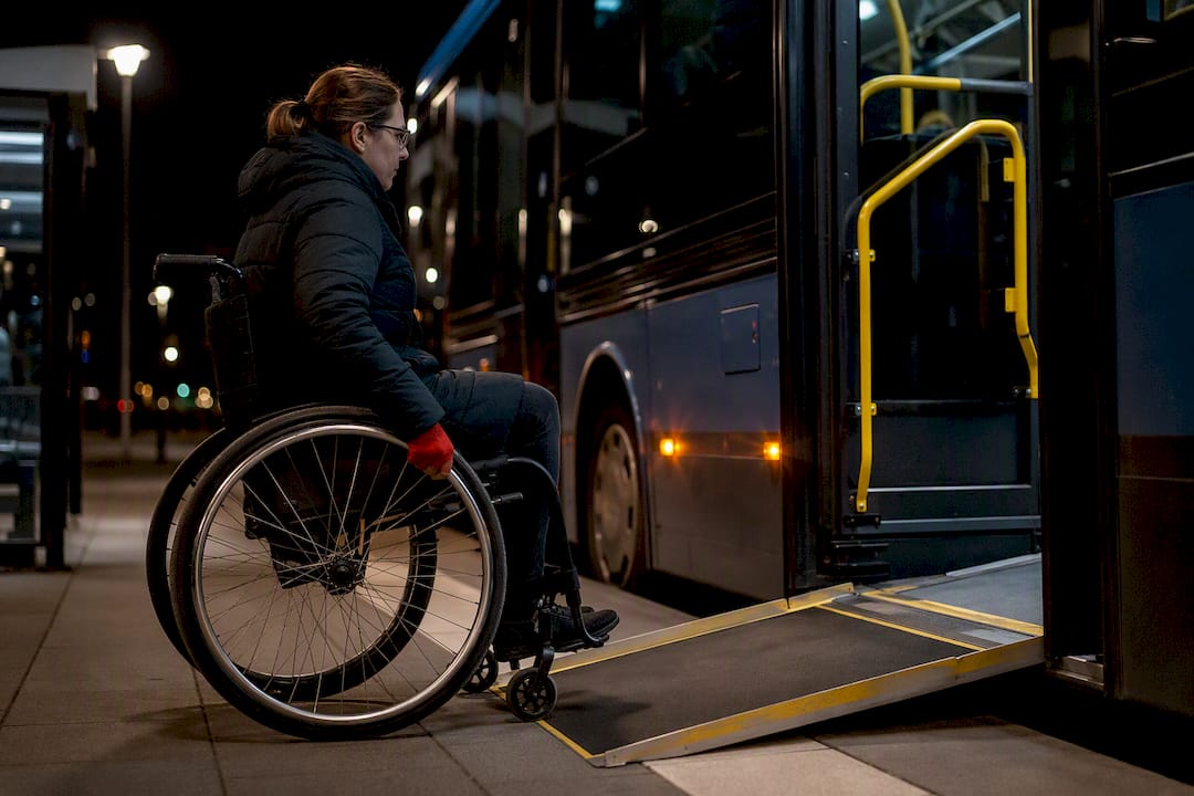 Rullstolsburen resenär använder rampen på låggolvsbussen