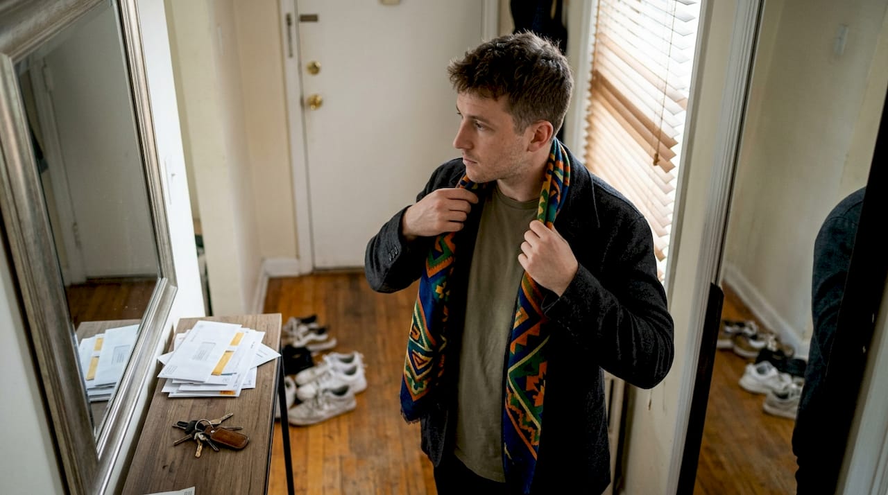 Man styling colorful designer scarf over jacket