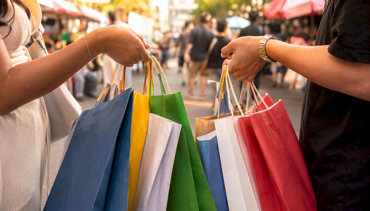 Hands holding multiple discount store shopping bags