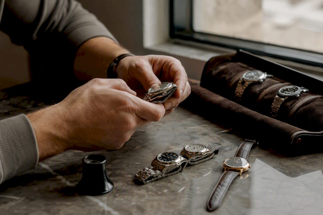 Hands arranging luxury wristwatches collection