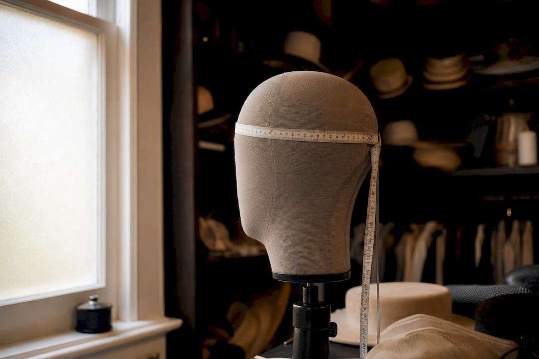 Tape measure around headed hat stand