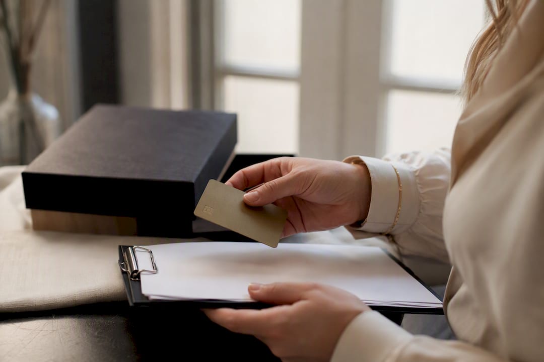 Hands holding payment card near shipping receipt and parcel
