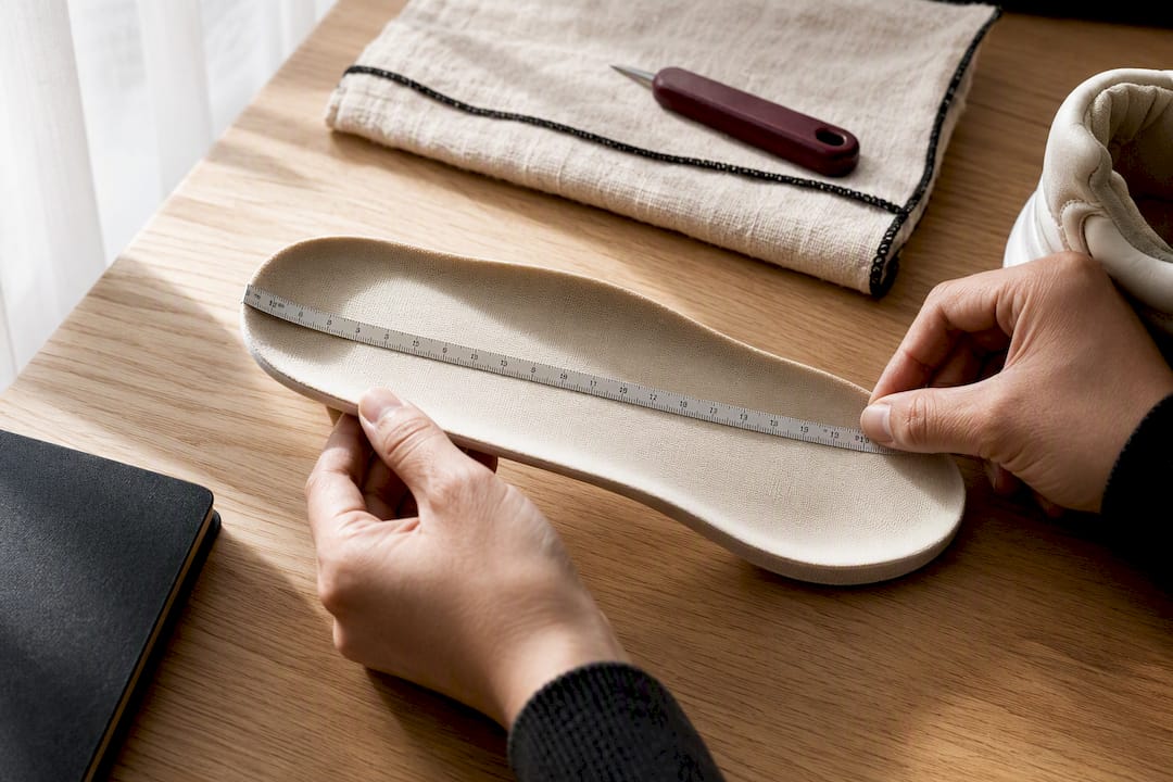 Hands measuring a sneaker insole