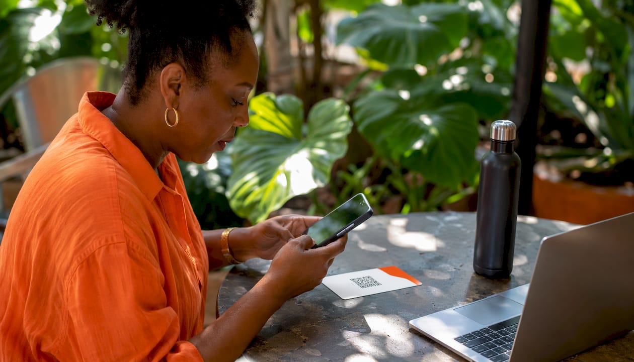 Hands scanning eSIM QR code in coworking space
