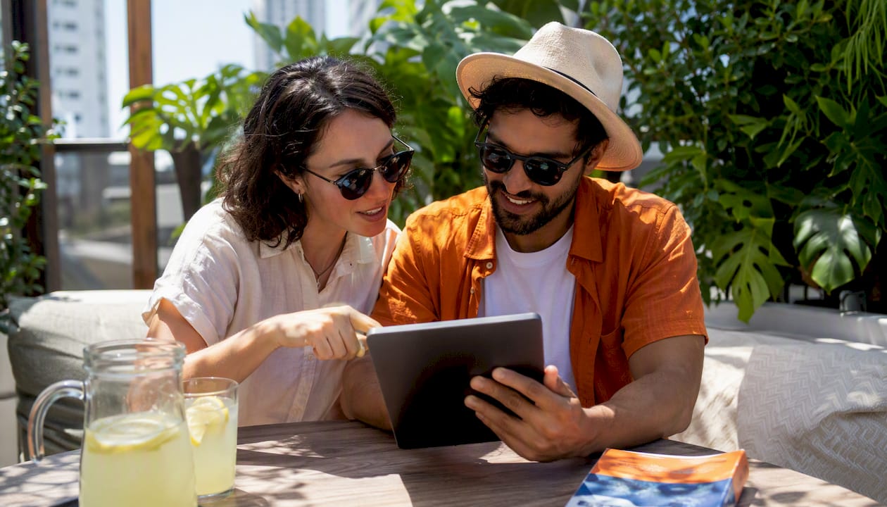 Travelers using tablet to select eSIM plans outdoors