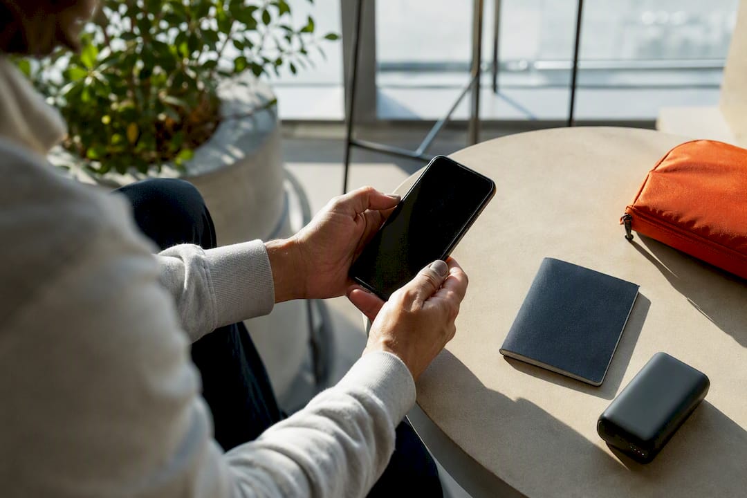 Hands preparing smartphone and travel accessories