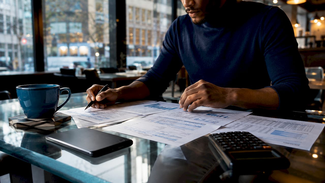 Trader’s hands handling hedging contracts and tools