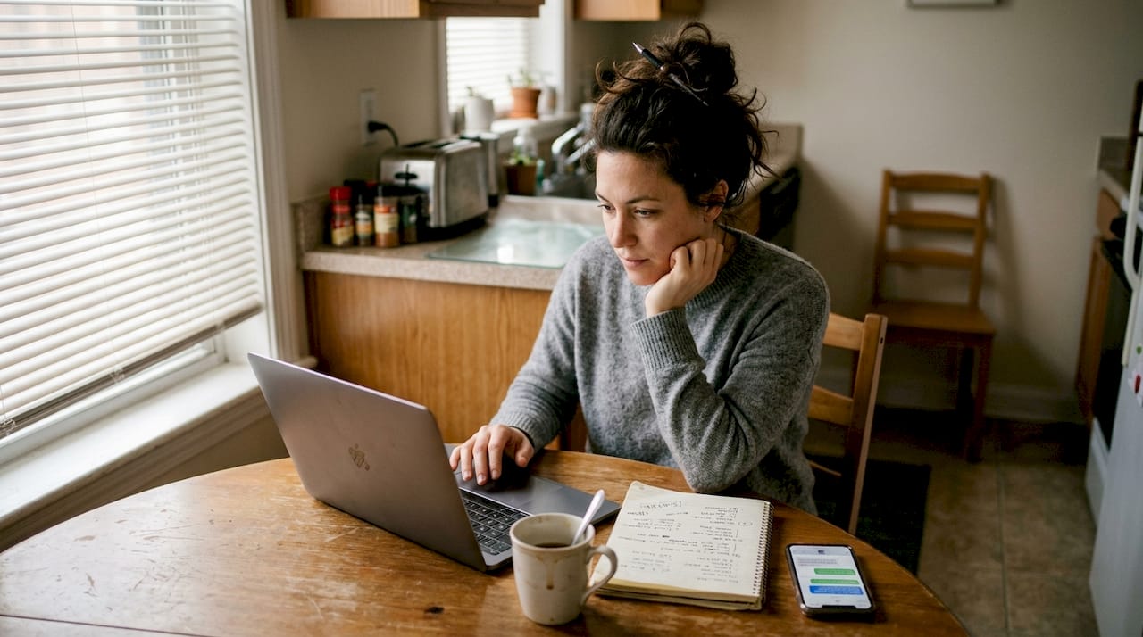 Woman researching therapy methods at kitchen table