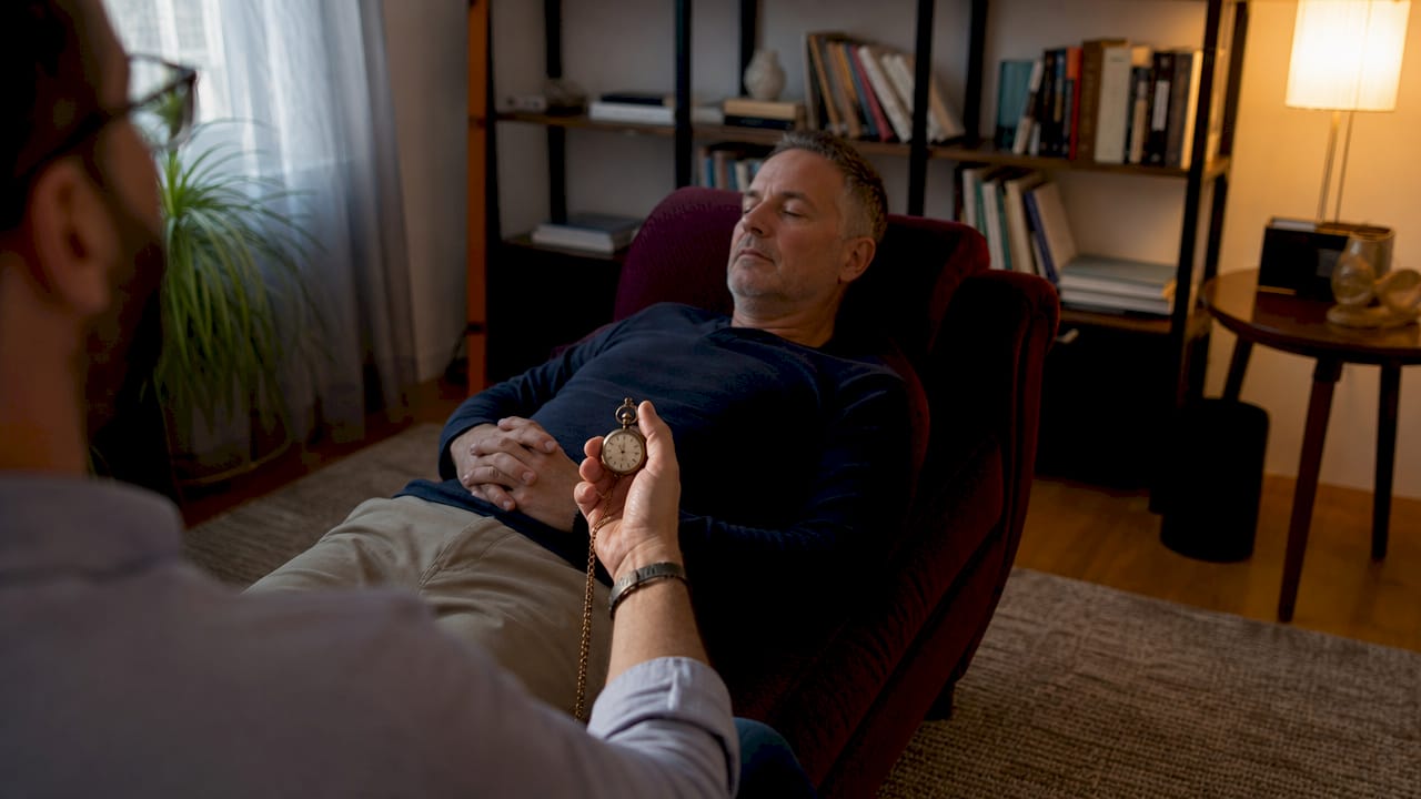 Client undergoing hypnosis induction in therapy room