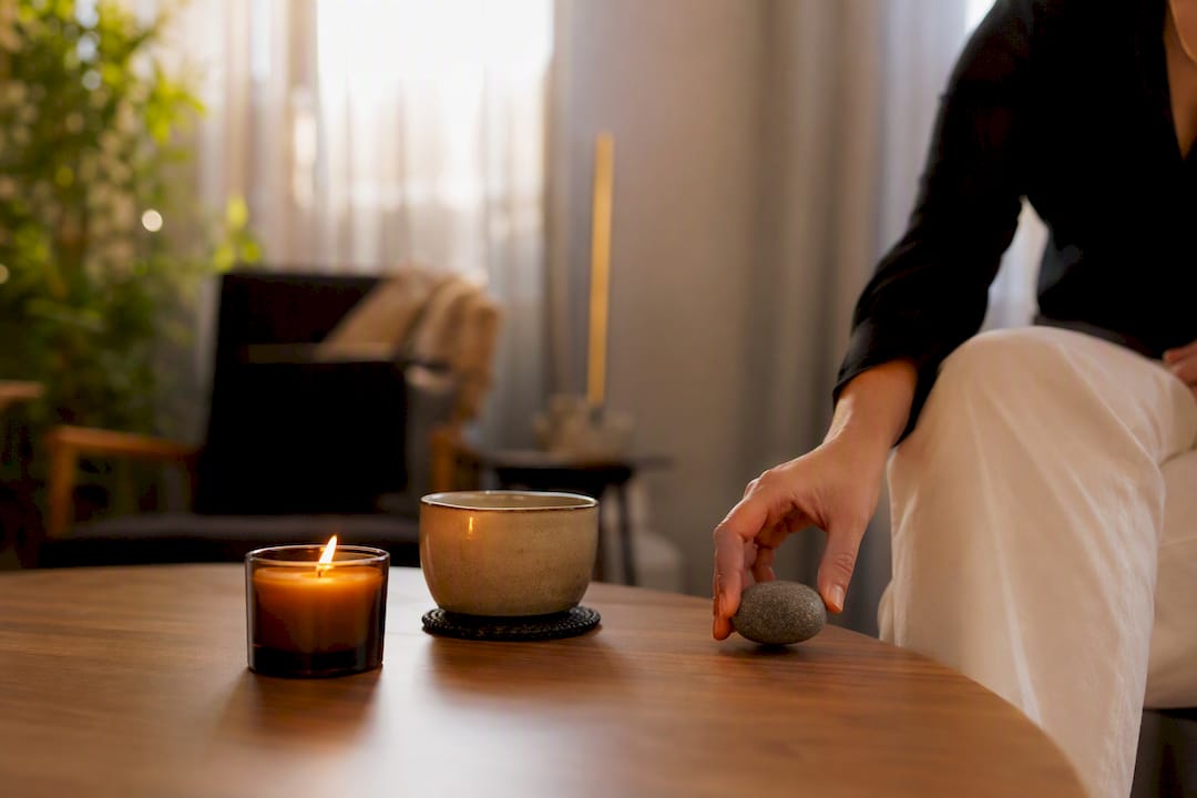 Hand adjusting grounding stone on therapy table