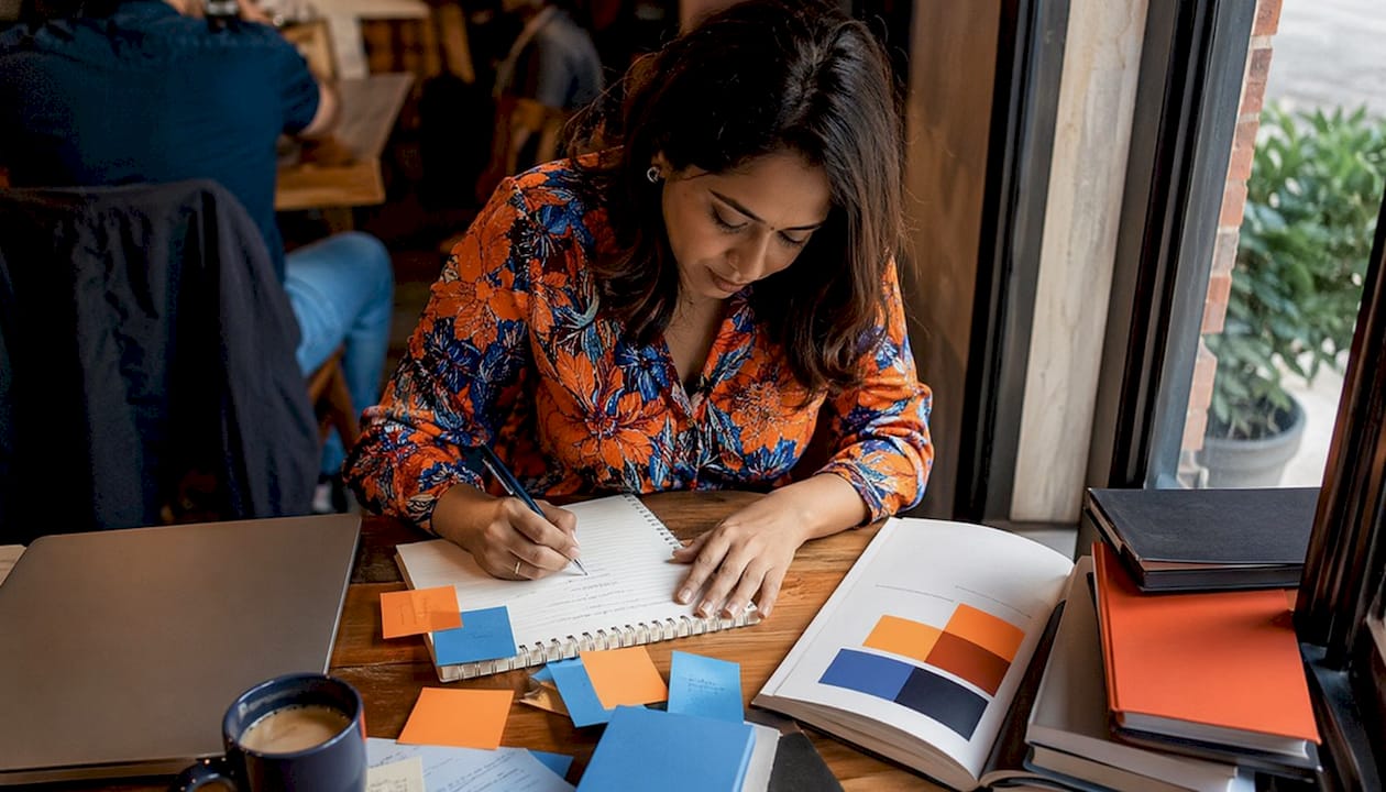 Woman writing brand statement in home office