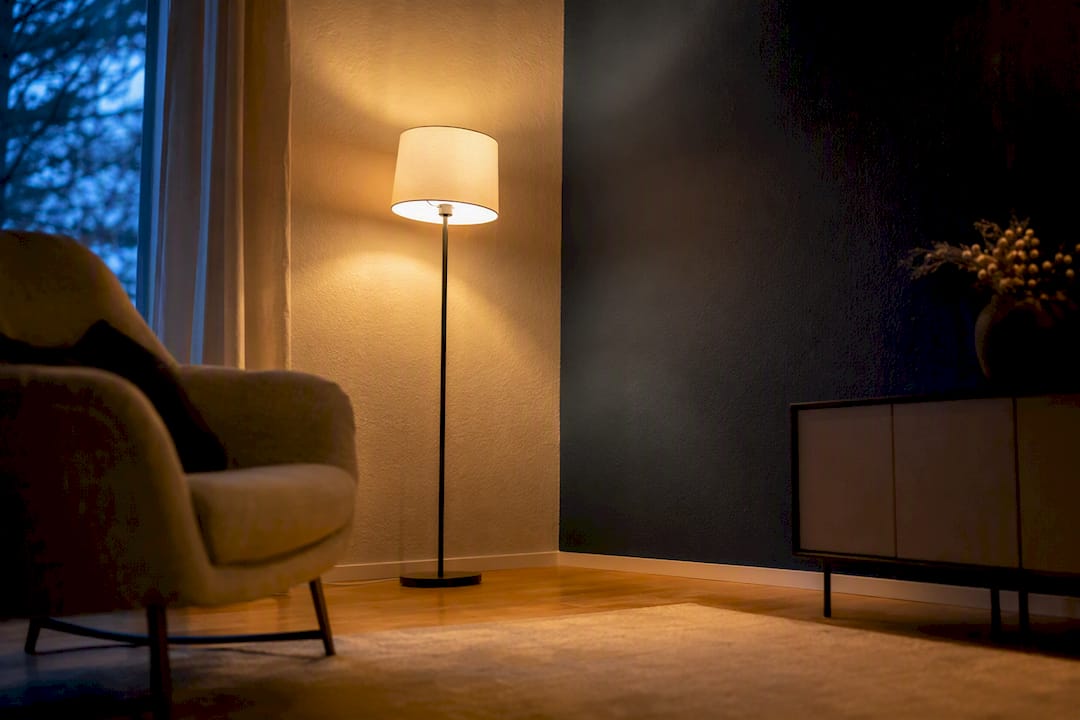 Wohnzimmer mit einer hellen und einer dunklen Wand sowie Lampenlicht