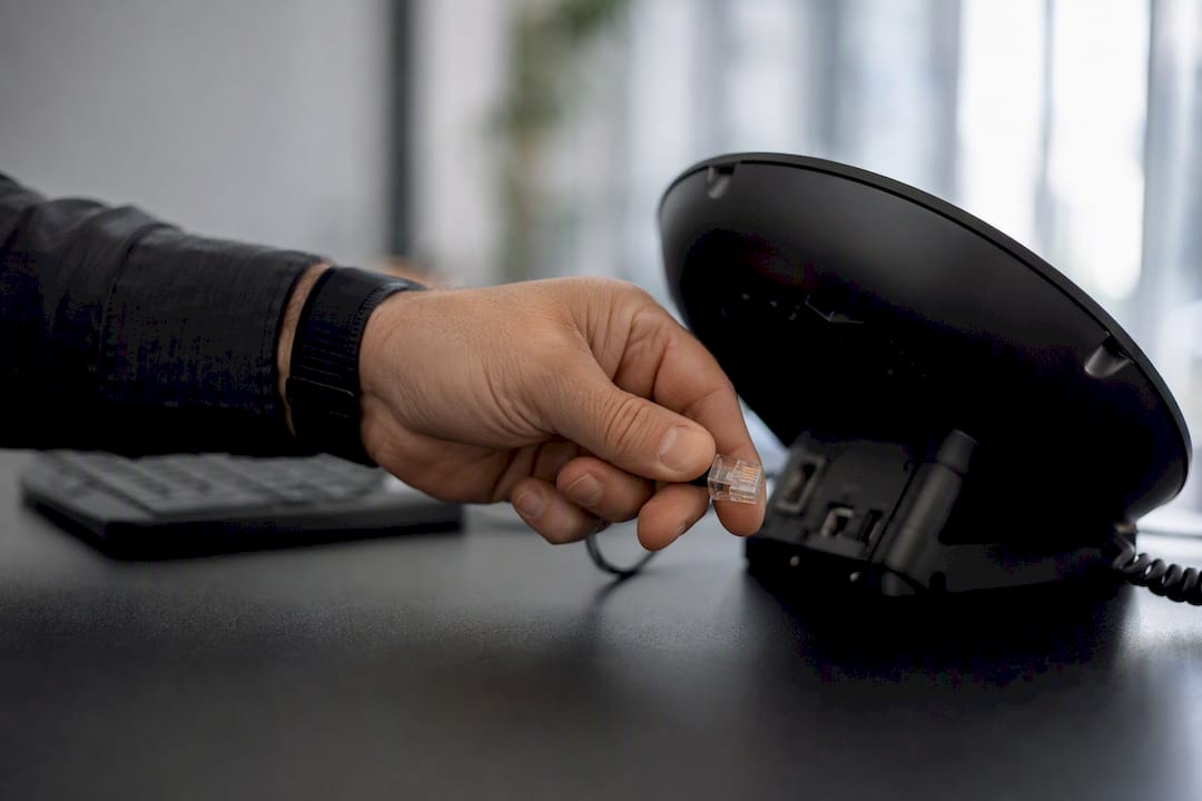 Hand richtet die Telefonkabelverbindung ein