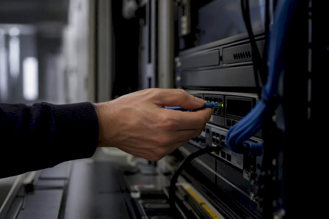 Hand, die ein Kabel an einem Tag-Management-Gerät justiert
