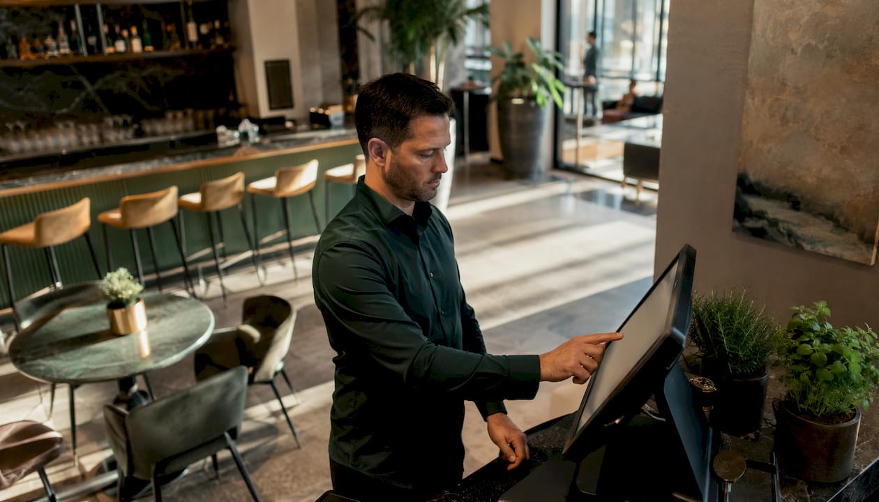 Ein Hotelmanager bedient den Self-Check-in-Automaten in der Hotellobby.