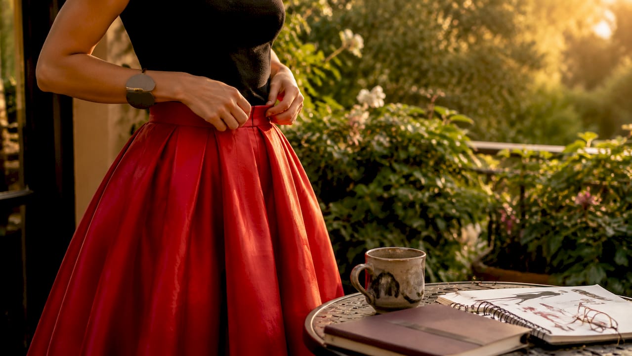 Close-up of hands adjusting bold skirt silhouette