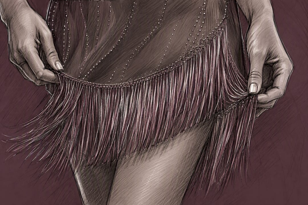 Hand holding fringe detail on luxury outfit