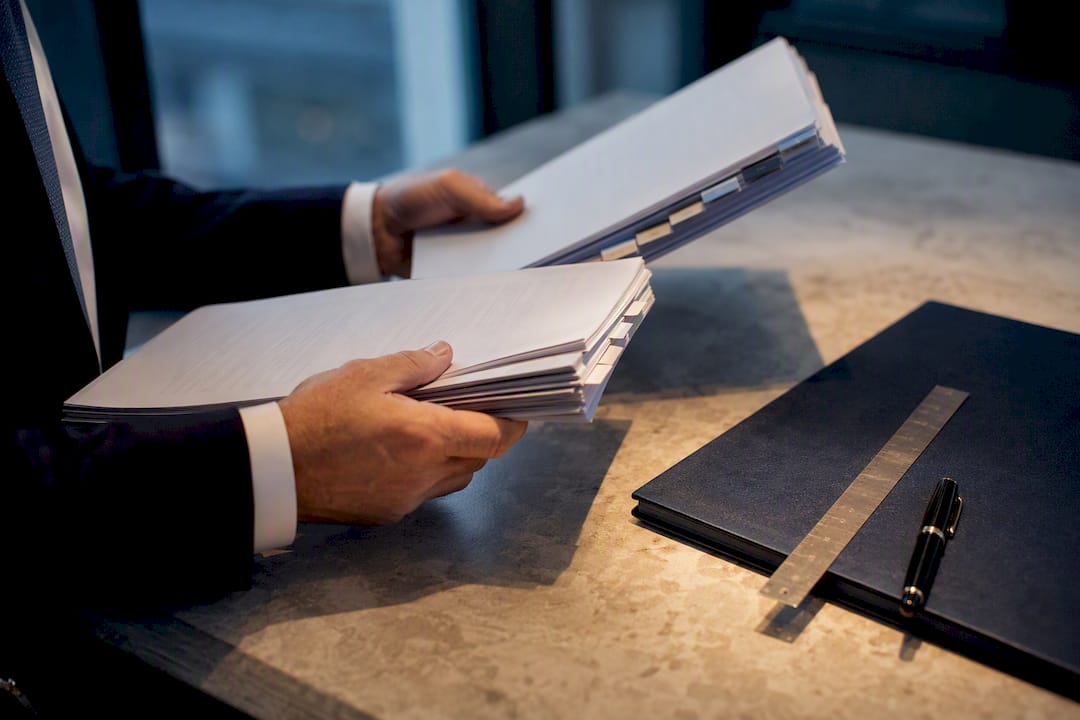 Hands reviewing tabbed finance agreement bundles