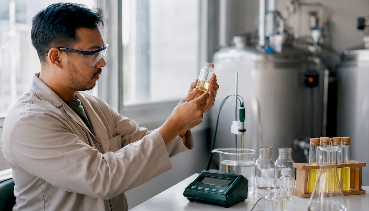 Technician holding lactic acid vial in lab