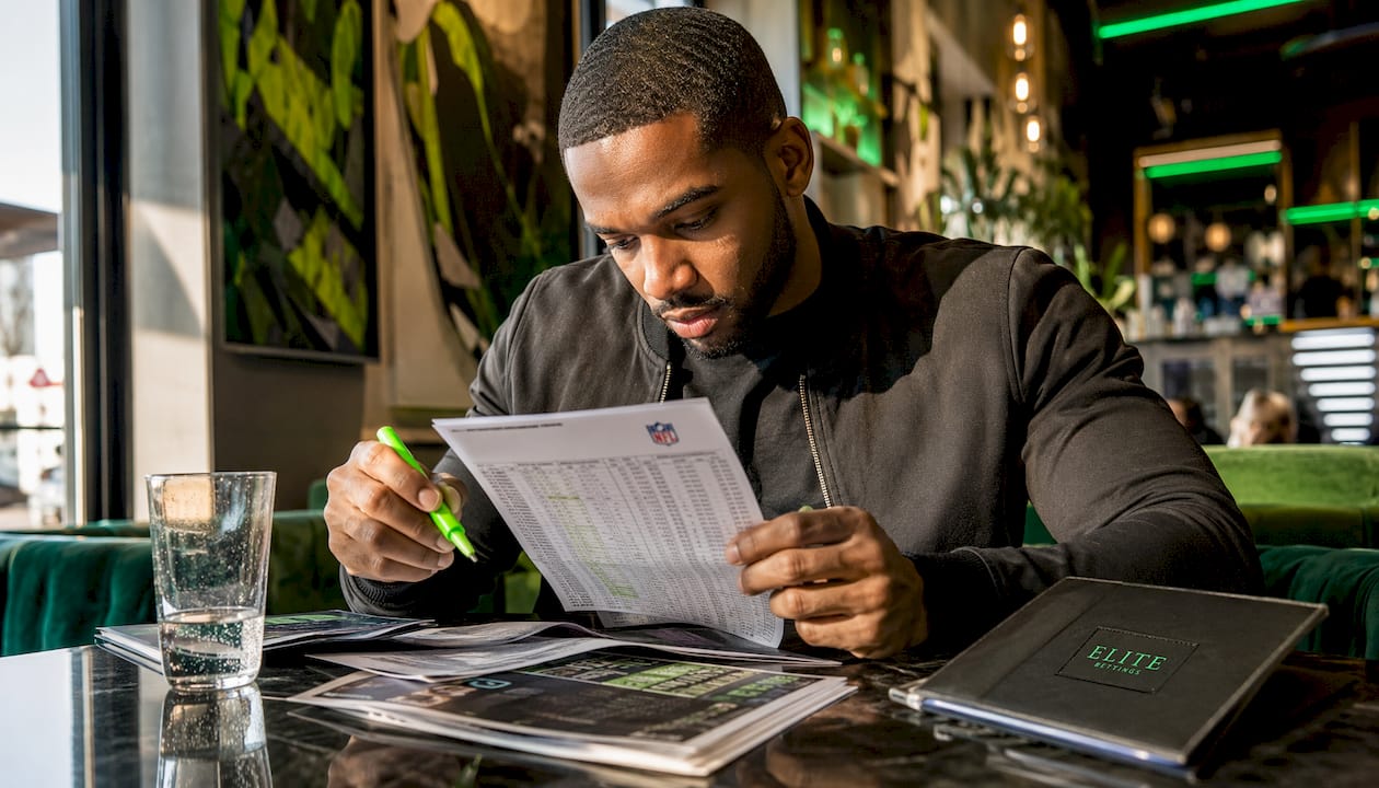 Man analyzing NFL teaser bets on desk