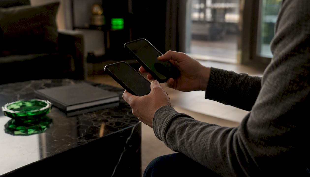 Hands placing arbitrage bets on phones