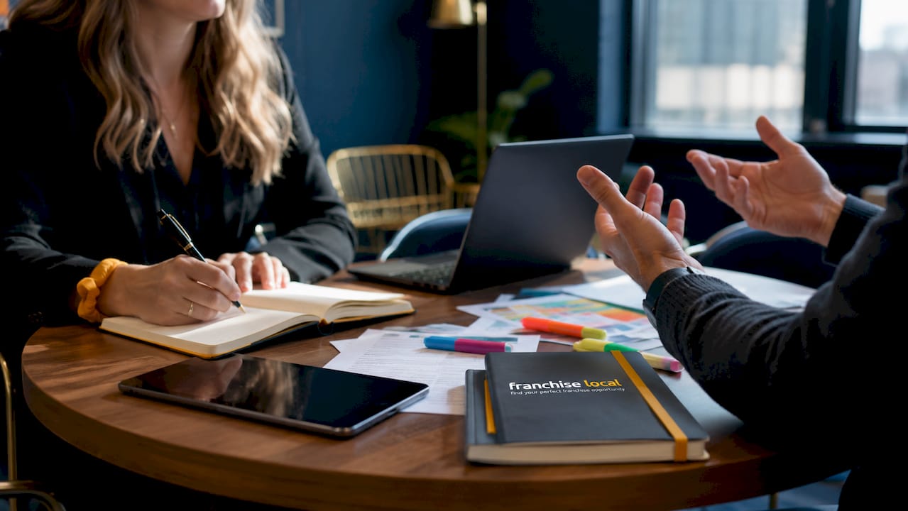 Franchisee autonomy explained: your 2026 guide Hands discussing franchise partnership documents