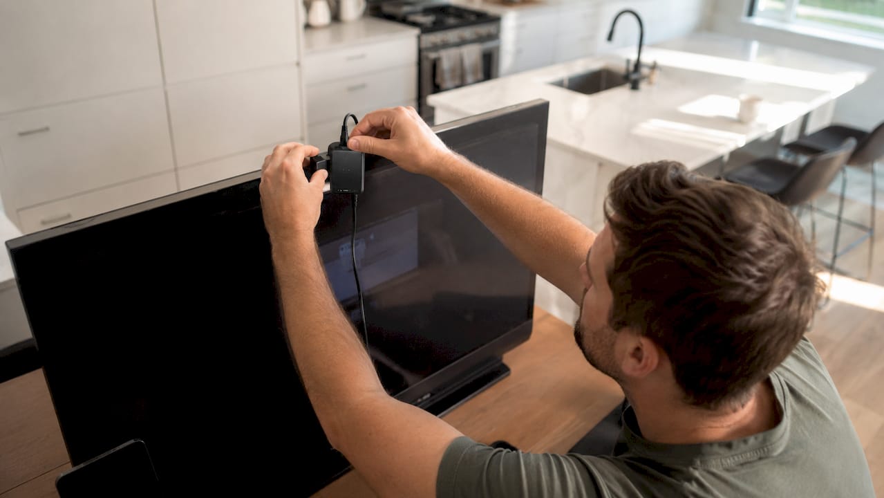 Close-up of hands calibrating monitor with colorimeter