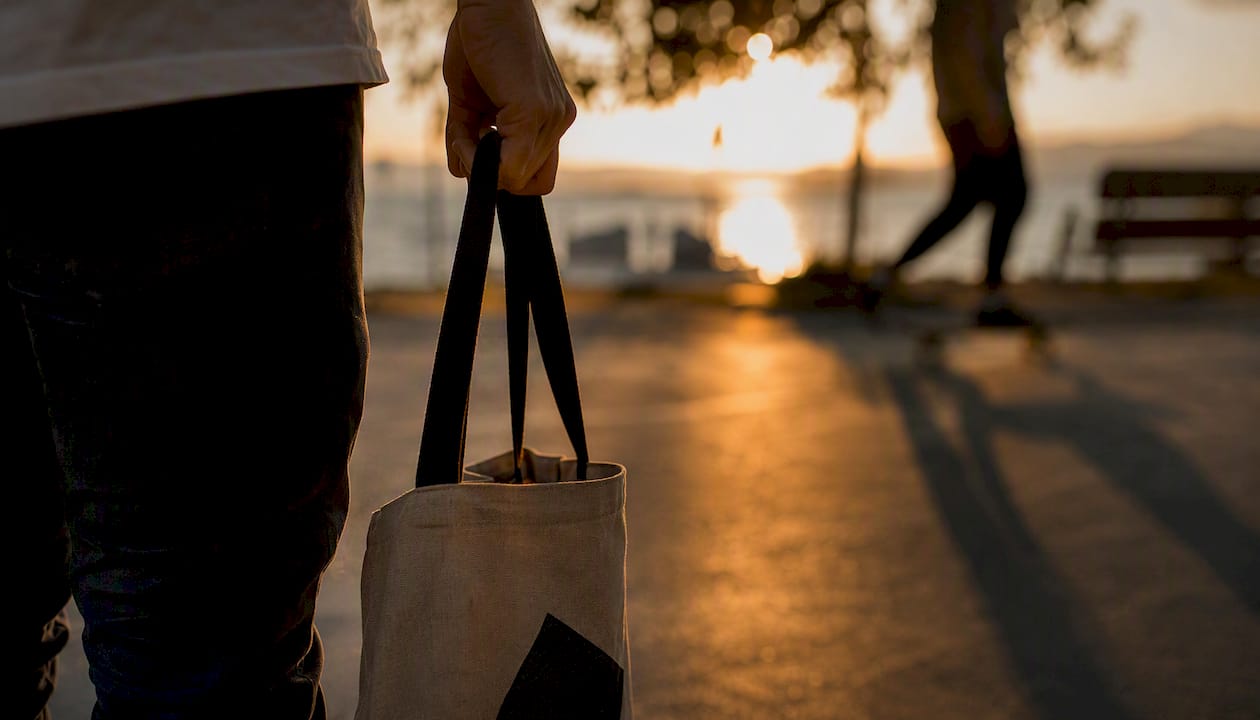 Hand holding tote bag outdoors
