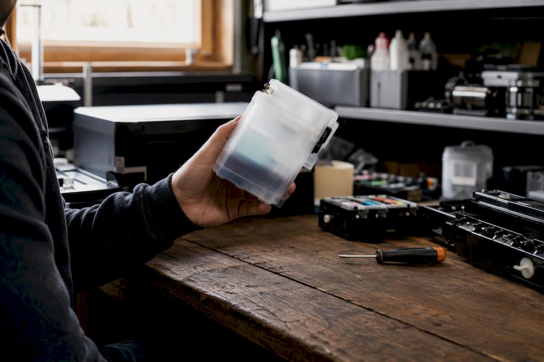 Technician shaking white ink cartridge before print run