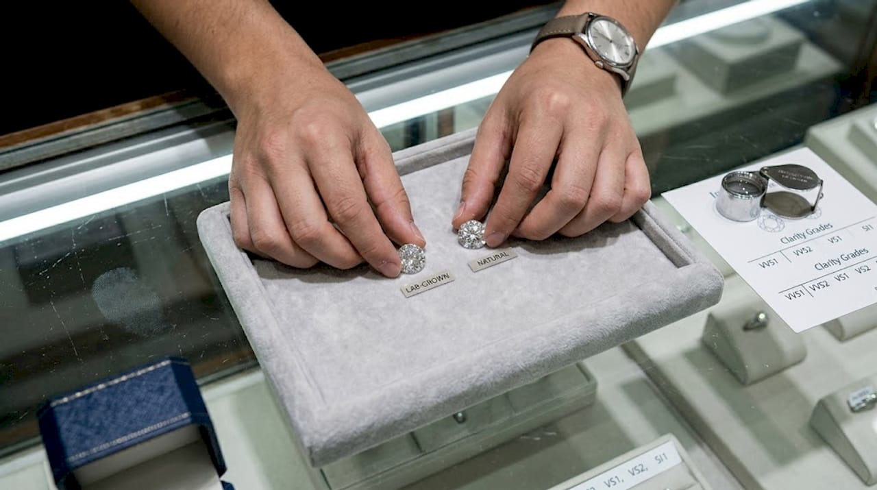 Hands comparing lab versus natural diamonds