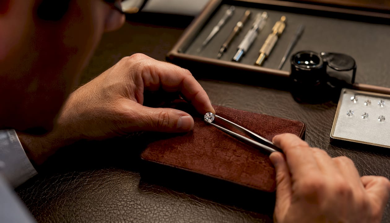 Jeweler's hands examining diamond closely