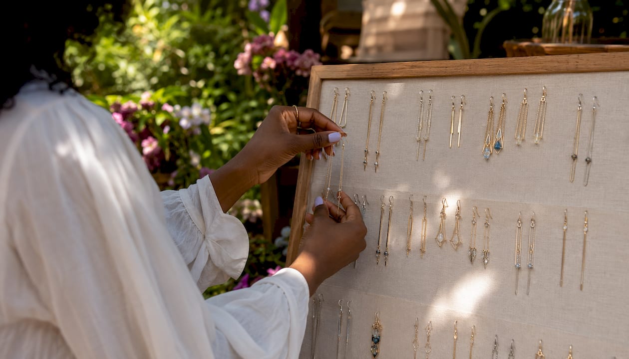 Hands selecting long drop earrings