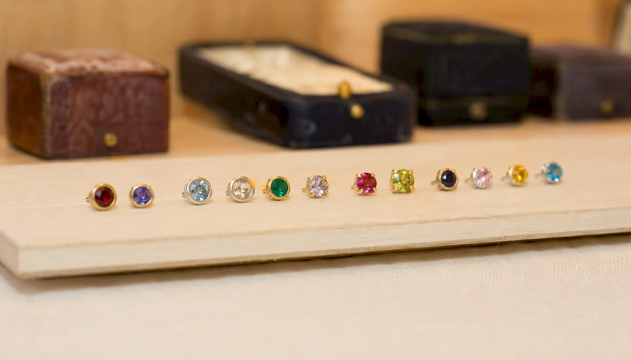 Close-up of birthstone earrings with bezel and prong settings
