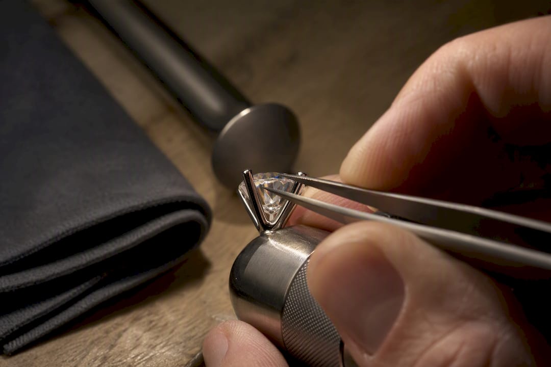 Jeweler examining diamond prongs and stone edge