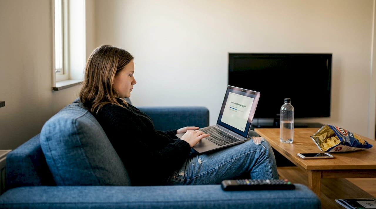 En tonåring ser till att datorns virusskydd är uppdaterat hemma.