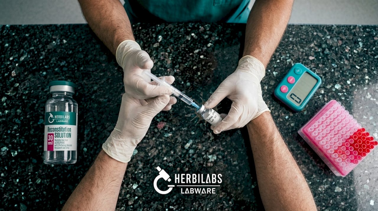 Technician reconstituting peptide with sterile water