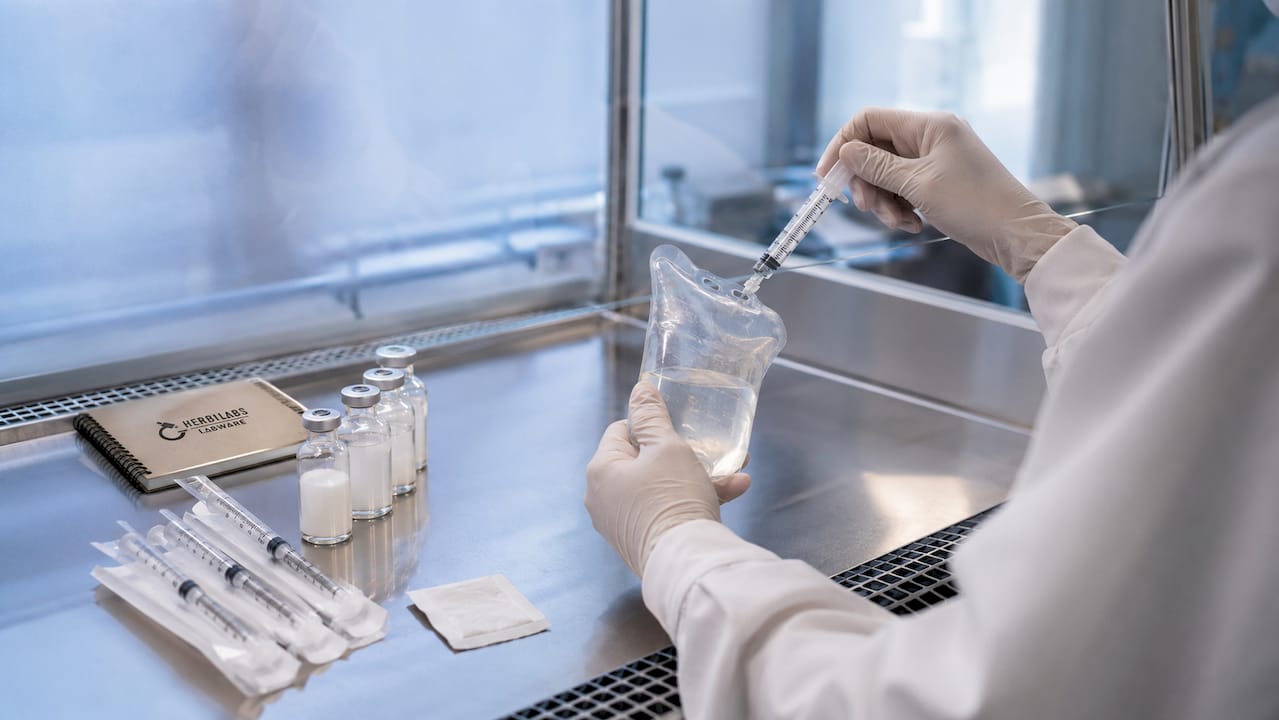 Gloved hands preparing sterile intravenous medication